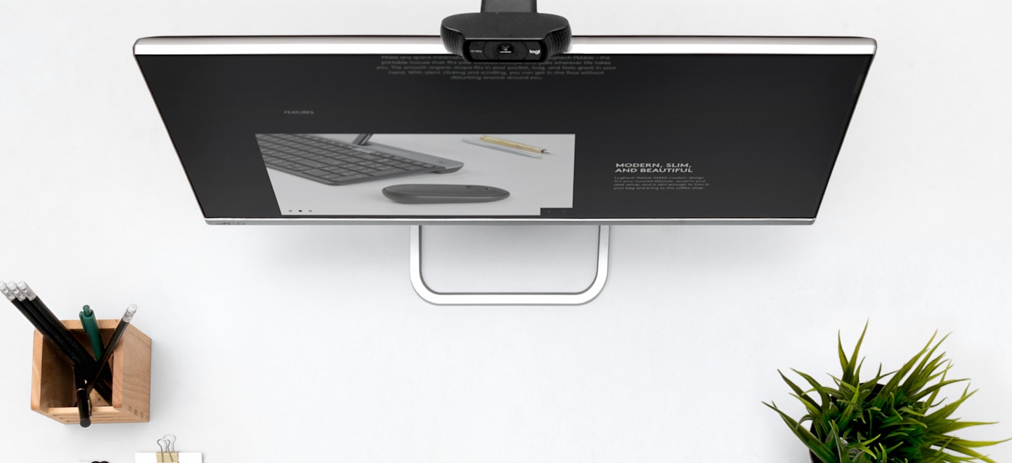 Logitech C920s webcam mounted on a desktop monitor in Logitech’s official workspace photograph